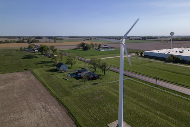 Una turbina eolica è vista in un campo di fronte a una fattoria.