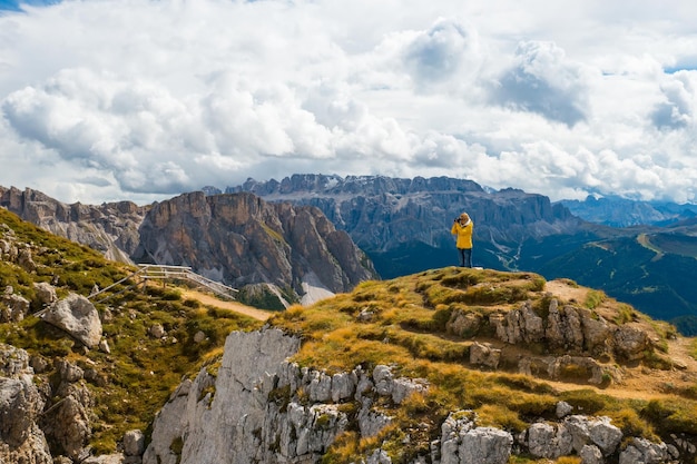 Una turista si trova sul bordo superiore della cresta di Seceda e scatta foto di paesaggi panoramici.