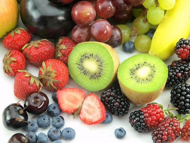 Una varietà di frutta tra cui kiwi, kiwi, more e kiwi sono su un tavolo.