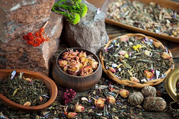 Una varietà di tè e tè sono esposti in una ciotola di legno.