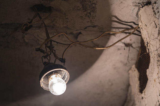 Una vecchia lampadina è appesa a un filo nel seminterrato