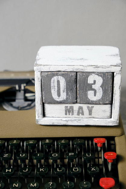 Una vecchia macchina da scrivere vintage retrò e un calendario in legno con l'immagine del 3 maggio Concetto per la Giornata della libertà di stampa