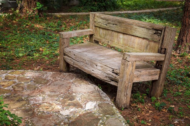 Una vecchia panca di legno rovinata dal vento e dalla pioggia si erge in un parco cittadino