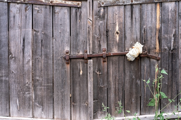 Una vecchia porta di legno e sgangherata chiusa a chiave. sfondo