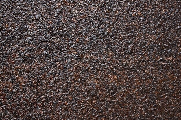 È una vecchia superficie metallica arrugginita di colore scuro Sfondo astratto con texture sulla corrosione dei metalli