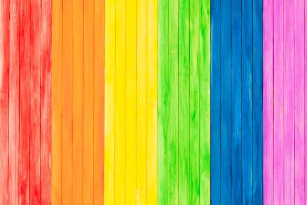 Una vecchia tavola di legno rustica con i colori dell'arcobaleno per il gay pride Bandiera gay