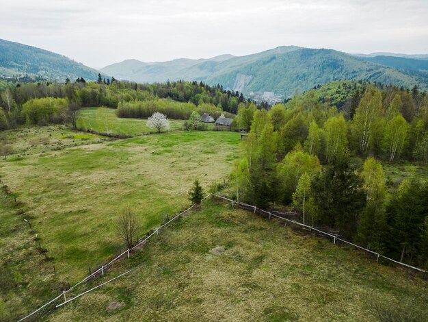 Una veduta aerea dall'alto di una fattoria con un'area recintata nelle verdi montagne dei Carpazi