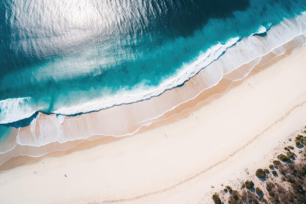 Una veduta aerea di una spiaggia con un oceano blu e sabbia bianca.