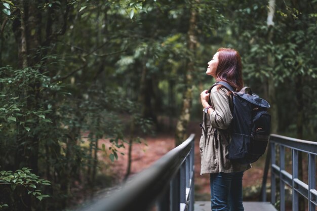 Una viaggiatrice con lo zaino che cammina nel bosco