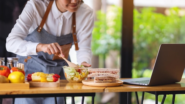 Una videoblogger donna che cucina in cucina e filma il concetto di lezione di cucina di apprendimento online