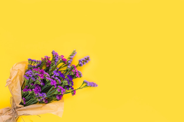 Una vista aerea del bouquet di fiori viola su sfondo giallo