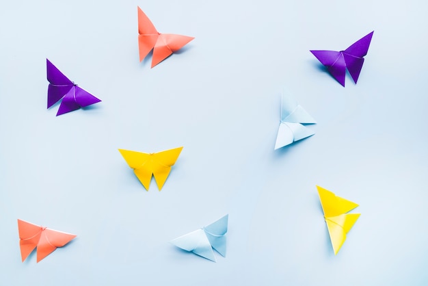 Una vista aerea di colorate farfalle di carta origami su sfondo blu