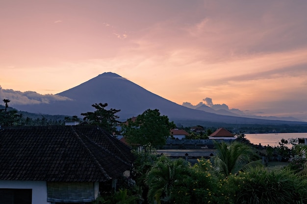 Una vista al tramonto di una montagna con un vulcano sullo sfondo