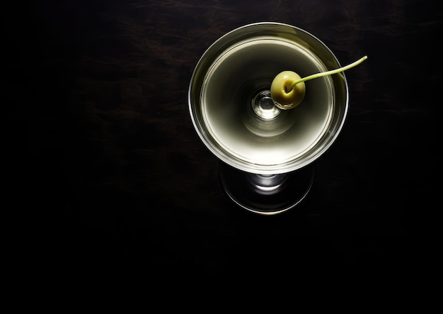 Una vista dall'alto di un cocktail Vesper Martini su un bancone bar lucido che mostra la sua chiarezza e s