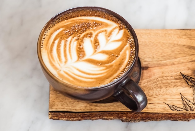 Una vista dall'alto di una tazza di caffè latte con schiuma a forma di foglia