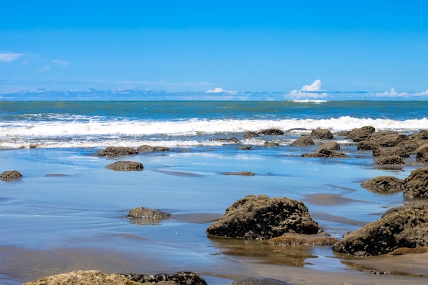 Una vista del paesaggio di una spiaggia rocciosa sotto il cielo blu