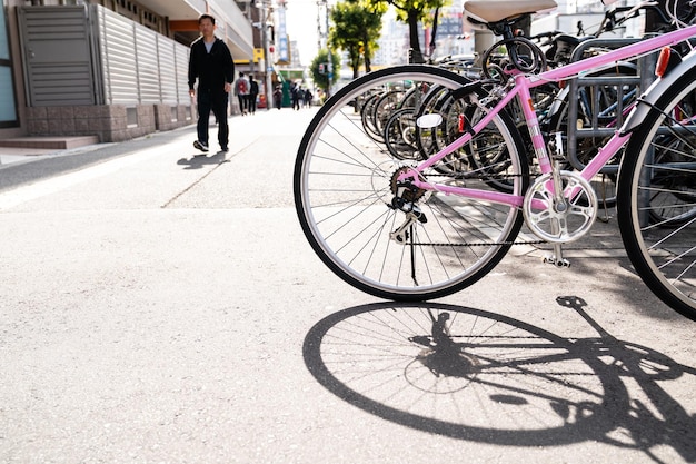 una vista di dozzine di biciclette parcheggiate sul marciapiede con poche persone a osaka in giappone.