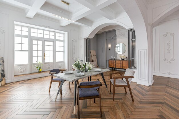 una vista di un tavolo da pranzo impostato in un elegante interno luminoso costoso di un enorme salotto in un palazzo storico con archi ad arco, colonne e pareti bianche decorate con ornamenti e stucco