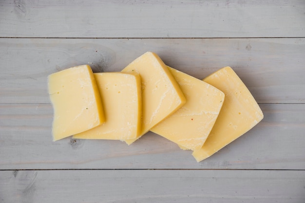 Una vista elevata di fette di formaggio fresco gouda sullo scrittorio di legno