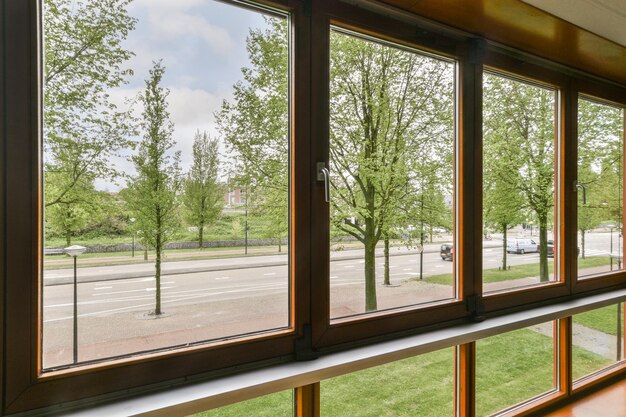 Una vista esterna dall'interno di un vagone che si affaccia sulla strada con alberi ed edifici sullo sfondo