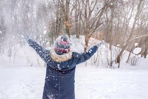 Una vista posteriore di un ragazzo in una giornata invernale sullo sfondo dell'albero