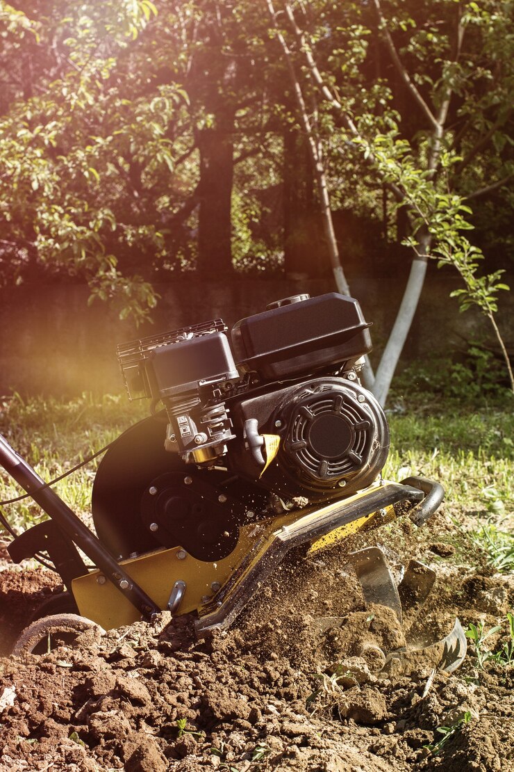 Una vista ravvicinata sul motocoltivatore durante il processo di aratro stagione primaverile concetto di lavori in giardino