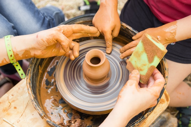 Una vista ravvicinata sul processo di produzione della ceramica sul tornio da vasaio con bambini Artigianato in argilla con bambini