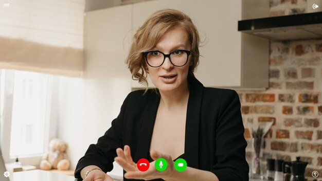 Una vista sullo schermo di un computer desktop dell'applicazione di telecomunicazioni durante una chat video in cui la specialista sta discutendo di affari da casa.