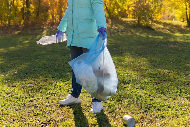 Una volontaria pulisce i rifiuti di plastica in natura.