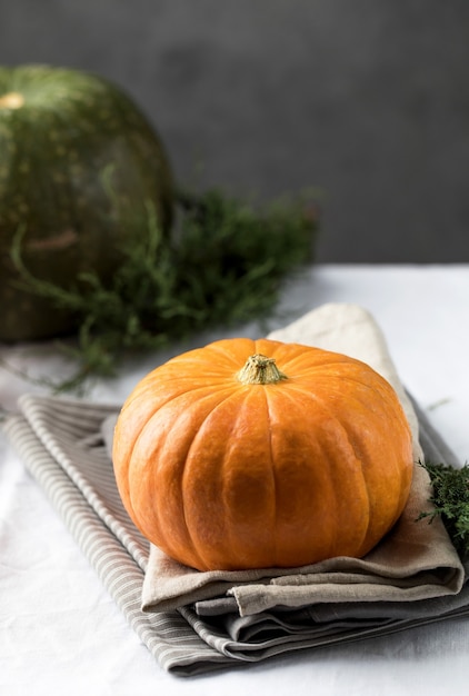 Una zucca rotonda arancione su una tovaglia di lino il concetto di raccolto autunnale