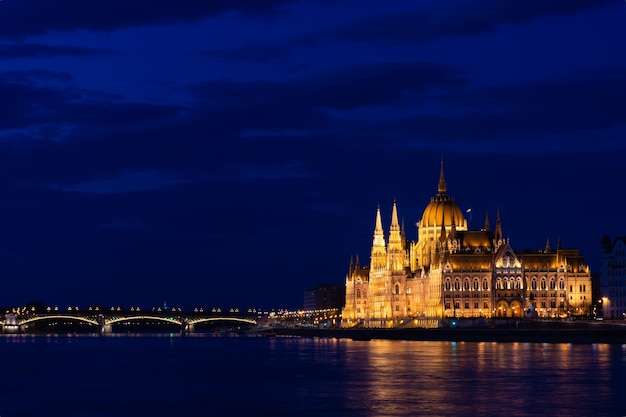 Ungheria, città di Budapest di notte, parlamento sul fiume, riflesso delle luci nell'acqua