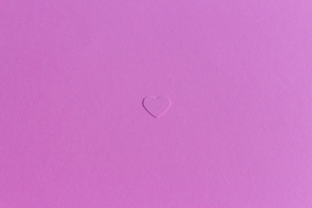 Unico piccolo cuore di carta su sfondo viola lilla