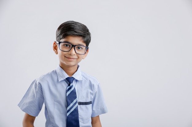 Uniforme ed occhiali da portare del piccolo ragazzo di scuola indiano / asiatico sveglio