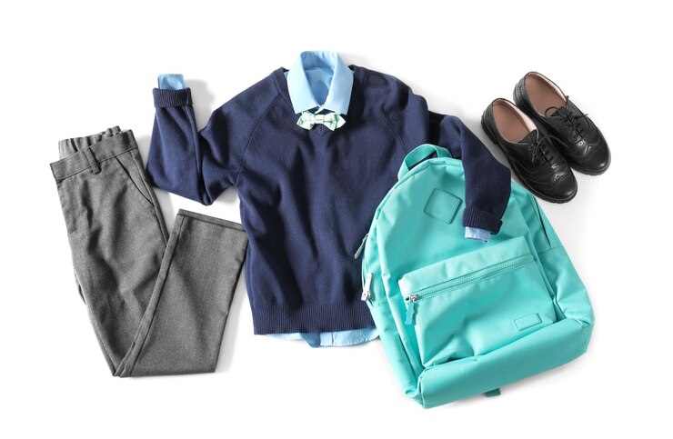 Foto uniforme scolastiche alla moda per ragazzi e zaino su sfondo bianco vista dall'alto