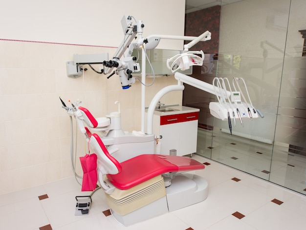 Unità dentale con strumenti di alimentazione superiore, sedia rossa, microscopio