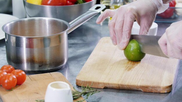 Uno chef che lavora in cucina a tagliare il lime