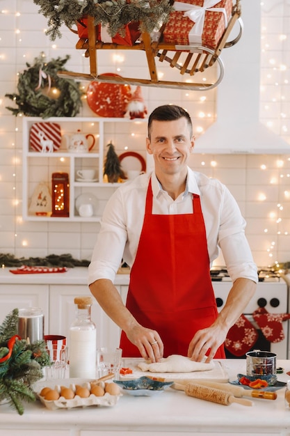 Uno chef maschio prepara l'impasto nella cucina di Natale prima del nuovo anno