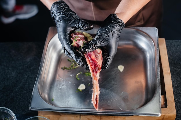 Uno chef professionista marina e prepara una succosa bistecca da un pezzo di carne fresca. Cucinare in un mca in un ristorante gourmet.