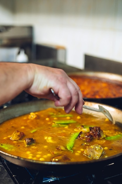 Uno chef sta cucinando un piatto di cibo con un cucchiaio.