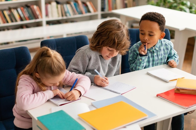 Uno scolaretto afroamericano che sbircia le risposte dei compagni di classe durante un test alla scuola elementare.