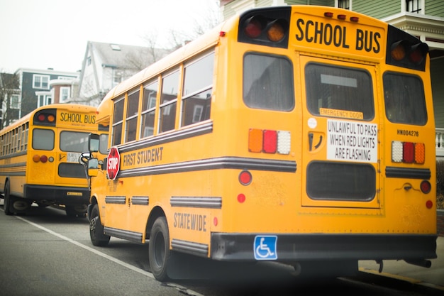 Uno scuolabus giallo con la scritta scuolabus sul retro.