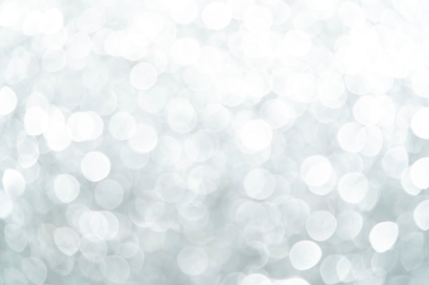 Uno sfondo bianco sfocato brillante per uno stato d'animo festivo Modello per biglietto di auguri per l'intrattenimento sfondo bianco astratto bokeh sfocato belle luci brillanti Natale