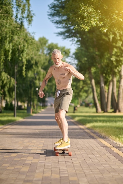 Uno skateboarder maschio che guida uno skateboard e mantiene l'equilibrio