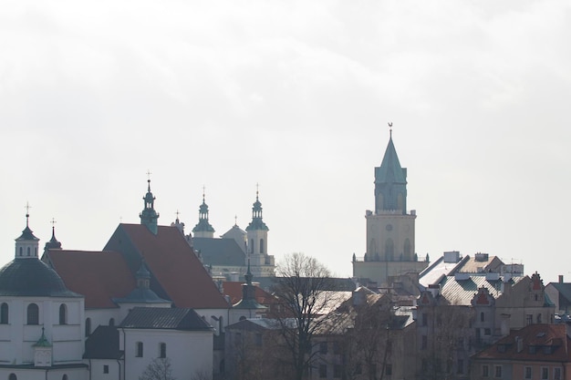 Uno skyline della città con una torre dell'orologio e una chiesa sullo sfondo.