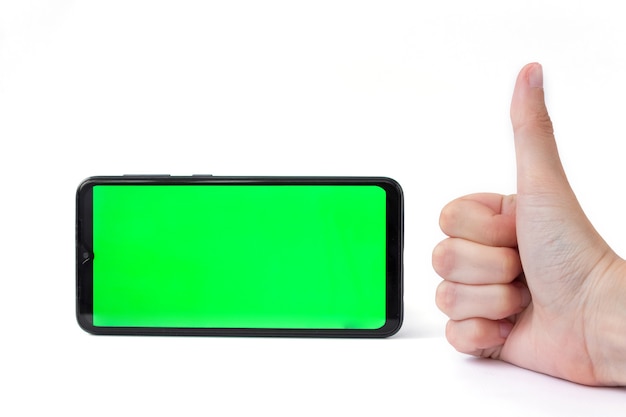 Uno smartphone in posizione orizzontale con uno schermo verde su sfondo bianco e una mano con il pollice alzato. Chiave cromatica. Modello
