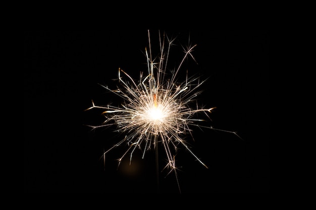 Uno sparkler è un tipo di fuoco d'artificio portatile che brucia lentamente mentre emette fiamme colorate, scintille e altri effetti. Sfondo scintillante.