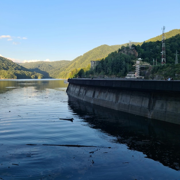 Uno specchio d'acqua con una strada e montagne sullo sfondo