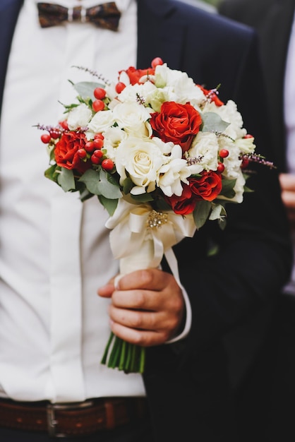 Uno sposo con bouquet da sposa, primo piano