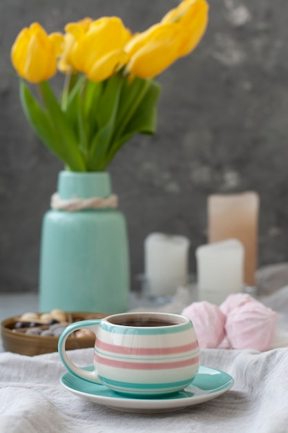 Uno spuntino gustoso: una tazza di caffè, un piatto di zefiro e una scatola di dolci.