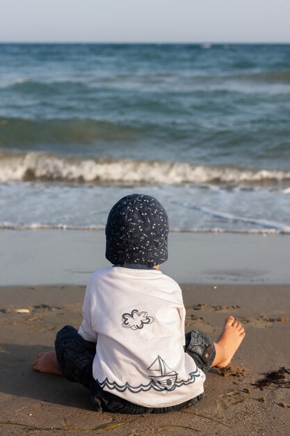 Uno stile di vita sano. Un ragazzino cammina e gioca in riva al mare.